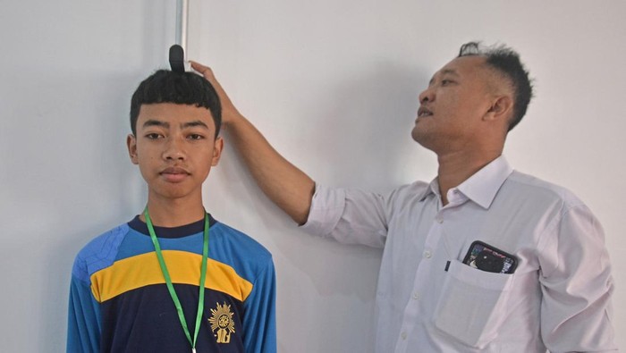 Petugas kesehatan mengukur tinggi badan seorang siswa sekolah rakyat saat pemeriksaan kesehatan di Sentra Terpadu Kartini, Temanggung, Jawa Tengah, Senin (14/7/2025). Pemeriksaan kesehatan meliputi kesehatan mata, telinga, gigi, tes darah, dan kondisi fisik untuk memastikan kesehatan siswa sekolah rakyat sebelum menjalani kegiatan belajar mengajar.  ANTARA FOTO/Anis Efizudin/rwa.
