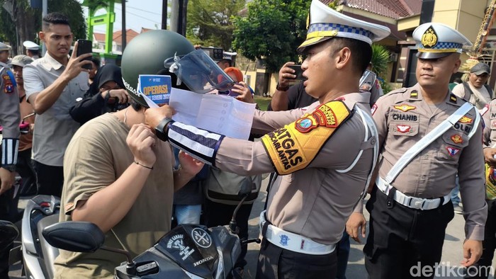 Kasat Lantas Polresta Sidoarjo Kompol Jodi Indrawan bagi-bagi helm.