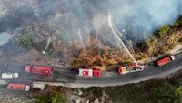 Tampilan drone menunjukkan Pertahanan Sipil Suriah, yang juga dikenal sebagai Helm Putih, sedang memadamkan kebakaran hutan di pedesaan Latakia, Suriah, 13 Juli 2025. Foto: REUTERS/Karam al-Masri