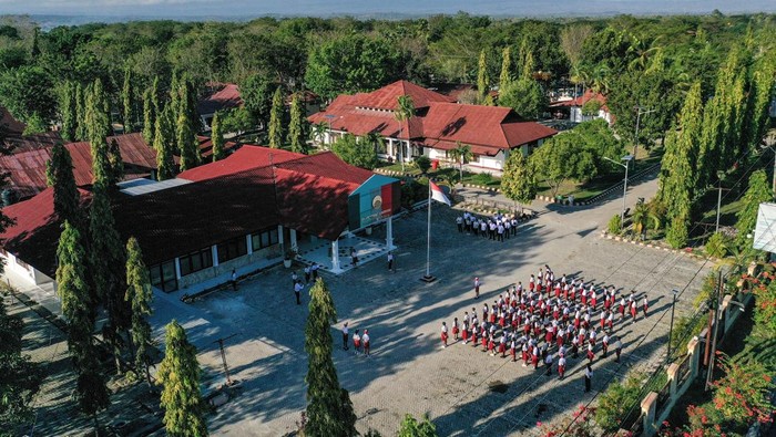 Foto udara sejumlah siswa sekolah rakyat mengikuti upacara bendera di Sekolah Rakyat Menengah Pertama 19 Kupang, Sentra Efata, Naibonat, Kabupaten Kupang, NTT, Senin (14/7/2025). Sebanyak 100 siswa jejang SMP mulai memasuki asrama dan menjalani masa pengenalan lingkungan sekolah (MPLS) tahun ajaran 2025/2026. ANTARA FOTO/Fauzan/rwa.