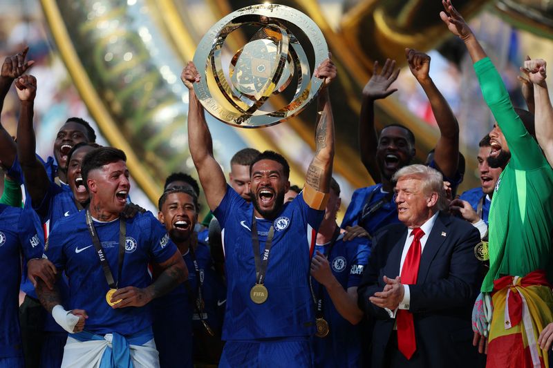 Momen Donald Trump Ogah Turun Podium, Ikut Pesta Juara Chelsea Soccer Football - FIFA Club World Cup - Final - Chelsea v Paris St Germain - MetLife Stadium, East Rutherford, New Jersey, U.S. - July 13, 2025 Chelsea's Reece James lifts the trophy as he celebrates with teammates after winning the FIFA Club World Cup as President Donald Trump applauds REUTERS/Hannah Mckay