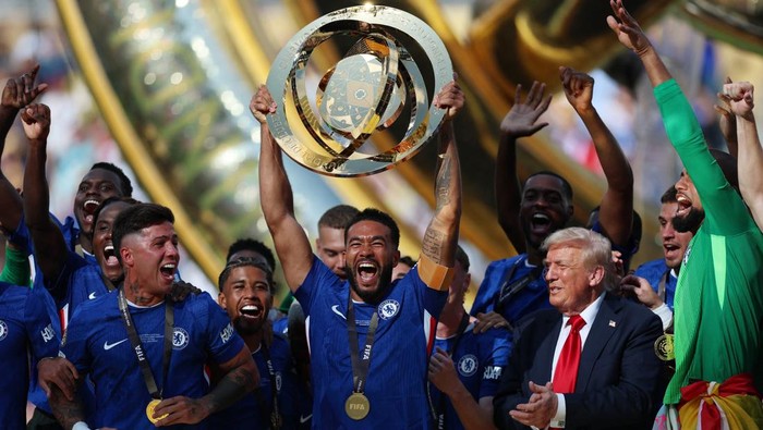 Soccer Football - FIFA Club World Cup - Final - Chelsea v Paris St Germain - MetLife Stadium, East Rutherford, New Jersey, U.S. - July 13, 2025 Chelseas Reece James lifts the trophy as he celebrates with teammates after winning the FIFA Club World Cup as President Donald Trump applauds REUTERS/Hannah Mckay