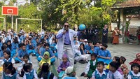Seorang guru sedang bercerita sambil membawa alat peraga peta globe saat MPLS di SDN 1 Jemur Wonosari Surabaya.