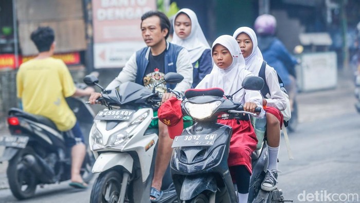 Pelajar Jabar Masuk Sekolah Lebih Pagi Pukul 06.30 WIB Sejumlah pelajar mengenakan topi saat memasuki area sekolah di SDN Jatimulya 02, Bekasi, Senin (14/7/2025).