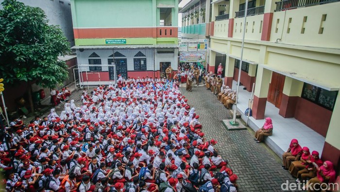 Pelajar Jabar Masuk Sekolah Lebih Pagi Pukul 06.30 WIB Sejumlah pelajar mengenakan topi saat memasuki area sekolah di SDN Jatimulya 02, Bekasi, Senin (14/7/2025).