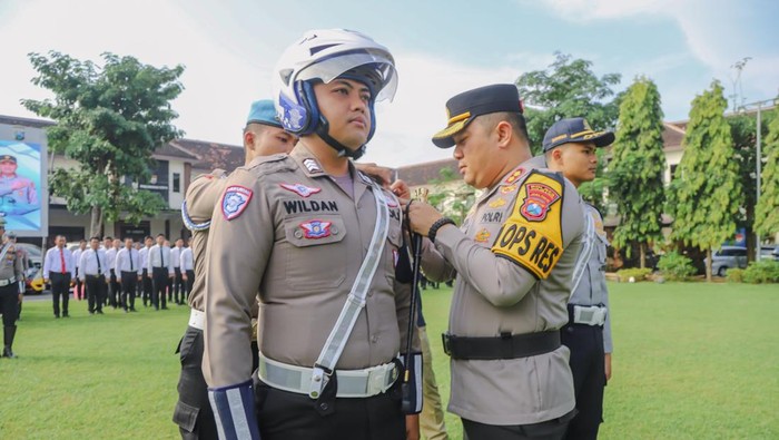 Penyematan pita biru ke seragam anggota polantas tanda dimulainya Operasi Patuh Semeru di Jombang.