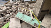 Garis polisi yang terpasang di sekeliling area rumah yang ambruk