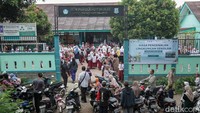 Orang tua mengantar anaknya pada hari pertama ke sekolah. 