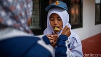 Satu per satu anak masuk ke kamar masing-masing ditemani orang tua mereka. Seorang anak terlihat sedang disuapi oleh orang tuanya sebelum berpisah.  
