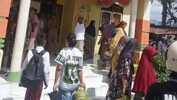 Warga di Desa Talabiu mengambil tabung gas dari mobil yang disandera di Kantor Desa Talabiu, Kecamatan Woha, Kabupaten Bima, NTB,Senin, (14/7/2025).