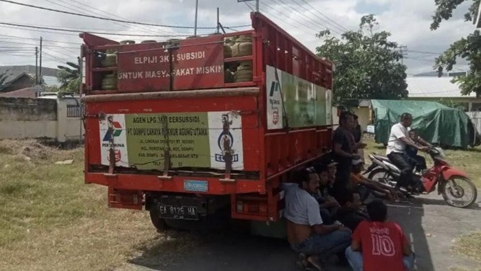 Warga di Desa Talabiu mengambil tabung gas dari mobil yang disandera di Kantor Desa Talabiu, Kecamatan Woha, Kabupaten Bima, NTB,Senin, (14/7/2025).