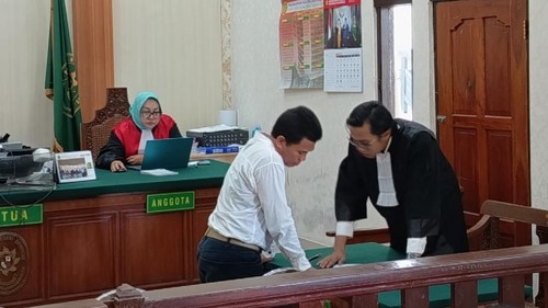 I Made Kertha saat berkoordinasi dengan penasihat hukumnya, Muh Lukman Hakim, dalam persidangan di PN Denpasar, Selasa (15/7/2025). (Ahmad Firizqi Irwan/detikBali)