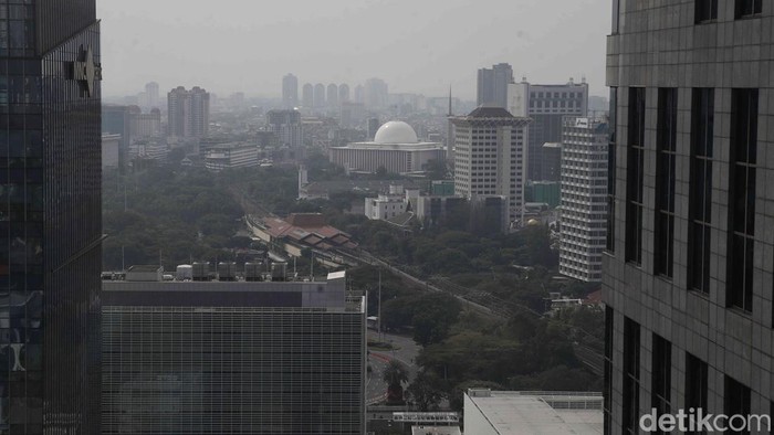 Kabut akibat polusi kembali menyelimuti langit Jakarta. Jarak pandang terganggu, landmark ikonik tertutup lapisan debu dan udara berwarna abu-abu, Selasa (15/7/2025).