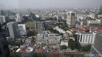 Gedung-gedung pencakar langit tampak samar tertutup kabut abu-abu tebal akibat kualitas udara buruk.