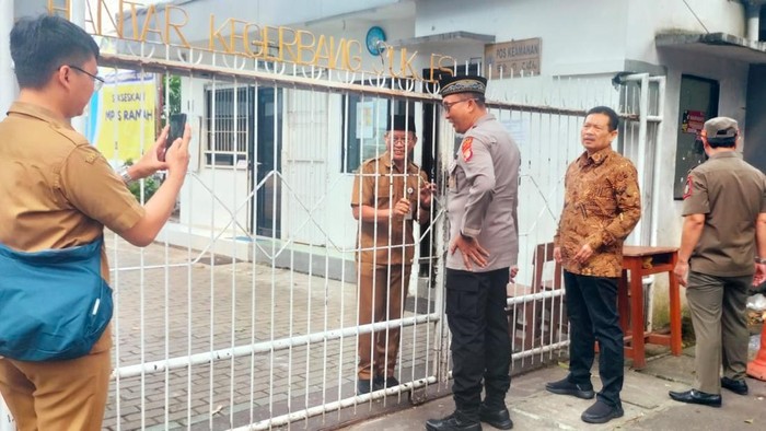 Momen Satpol PP didampingi polisi dan TNI membongkar gembok akses menuju SMAN 8 Tangsel, di hari pertama masuk sekolah, Senin (14/7/2025).