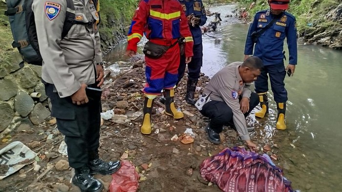 Petugas mengevakuasi mayat bayi di Kali Ciluar, Kota Bogor, Selasa (15/7/2025).