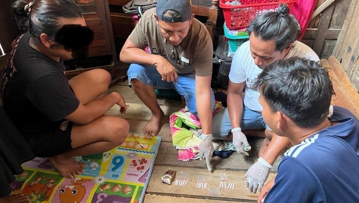 Petugas saat menemukan barang bukti sabu-sabu saat penggerebekan dua orang wanita dan seorang pria di Dompu Senin (14/7/2025). (IST)