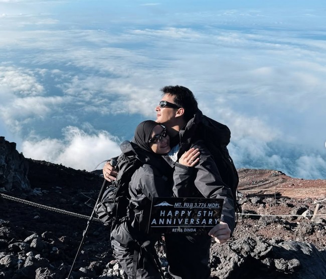 Keduanya pun memamerkan kemesraan mereka di atas gunung Fuji. Rey menyebut bahwa bukan puncak Fuji yang paling berkesan, melainkan perjalanan dan kebersamaan mereka sepanjang pendakian. Perayaan kecil ini menjadi kenangan besar yang tak terlupakan. Foto: Instagram/@rey_mbayang