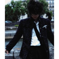 Aksen pita hitam yang menjuntai di sisi jaket menambahkan sentuhan chic, sementara bros berbentuk serangga berwarna perak statement elegan—ikonik dalam gaya Chanel. Foto: Instagram/@yibo.w_85