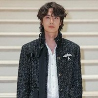 Wang Yibo mengenakan long tweed jacket hitam dari koleksi womenswear Chanel. Jaket tersebut memiliki detail tekstur woven khas maison Prancis, dengan sentuhan kilau halus yang mewah elegan. Foto: Thomas SAMSON / AFP