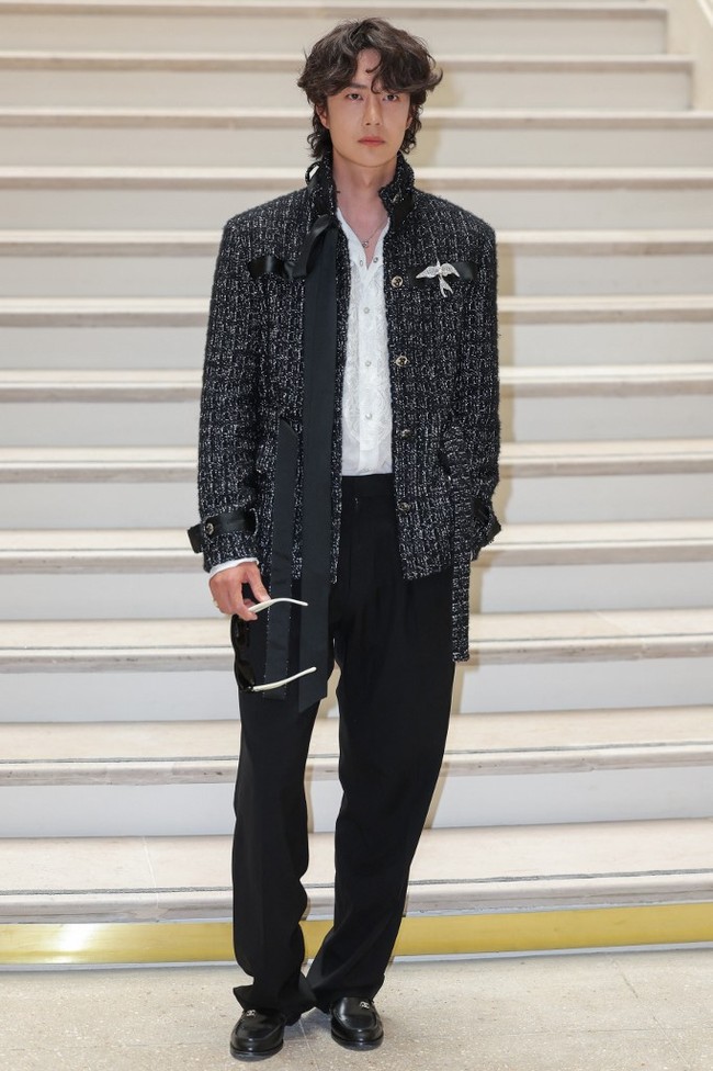 Celana panjang hitam berpotongan relaxed menyeimbangkan keseluruhan look. Sepatu loafers hitam mengokohkan aura maskulin. Foto: Thomas SAMSON / AFP