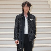 Celana panjang hitam berpotongan relaxed menyeimbangkan keseluruhan look. Sepatu loafers hitam mengokohkan aura maskulin. Foto: Thomas SAMSON / AFP