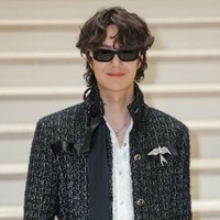 Wang Yibo tampak memegang clutch berbentuk box dengan handle putih yang kontras, menciptakan vibe edgy yang kontemporer. Foto: Thomas SAMSON / AFP