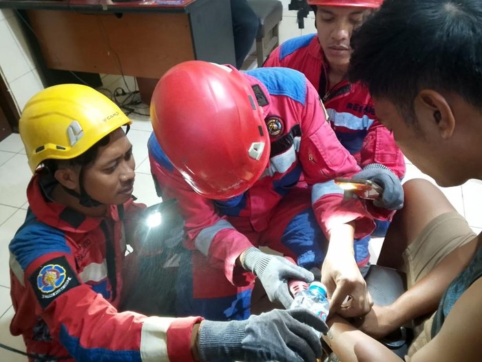 Petugas damkar Surabaya saat berusaha melepas borgol tahanan yang macet di Mapolsek Semampir