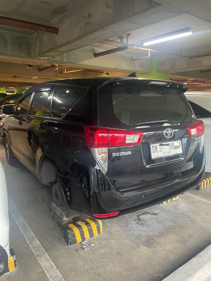 Kondisi mobil Innova yang dicuri ban beserta velg di parkiran international lantai 3 Bandara Internasiona I Gusti Ngurah Rai, Selasa (15/7/2025). (Dok. Polres Bandara)