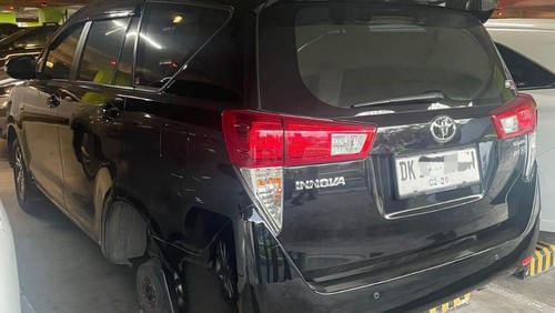 Kondisi mobil Innova yang dicuri ban beserta velg di parkiran international lantai 3 Bandara Internasiona I Gusti Ngurah Rai, Selasa (15/7/2025). (Dok. Polres Bandara)