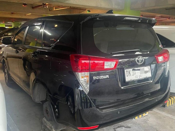 Kondisi mobil Innova yang dicuri ban beserta velg di parkiran international lantai 3 Bandara Internasiona I Gusti Ngurah Rai, Selasa (15/7/2025). (Dok. Polres Bandara)