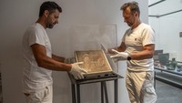 Petugas museum memasang kembali mosaik Romawi kuno di Taman Arkeologi Pompeii, Italia, Senin (15/7/2025). Mosaik itu baru saja dikembalikan setelah lebih dari 80 tahun dicuri oleh seorang perwira Nazi saat Perang Dunia II. (Pompeii Archaeological Park/Ministry of Culture/Handout via REUTERS)  