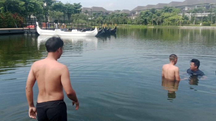 Proses evakuasi handphone yang jatuh ke kolam.