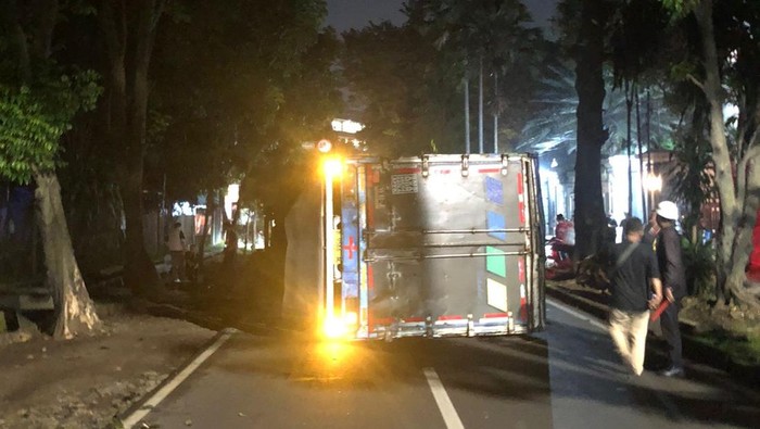 Satu unit truk kontainer terguling usai menabrak pohon di Jl Pemuda, Tanahsareal, Kota Bogor. (dok. Polresta Bogor)