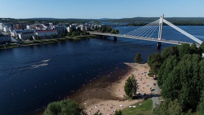 Sungai Kemijoki Jadi Pelarian Warga Finlandia Saat Cuaca Panas Cuaca panas ekstrem menyelimuti Rovaniemi, Finlandia. Warga memadati tepian Sungai Kemijoki untuk berenang dan bersantai di bawah terik matahari.
