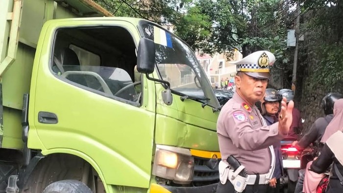 Truk muatan hebel terguling dan menimpa mobil di tanjakan Sawangan, Depok, Rabu (16/7/2025).