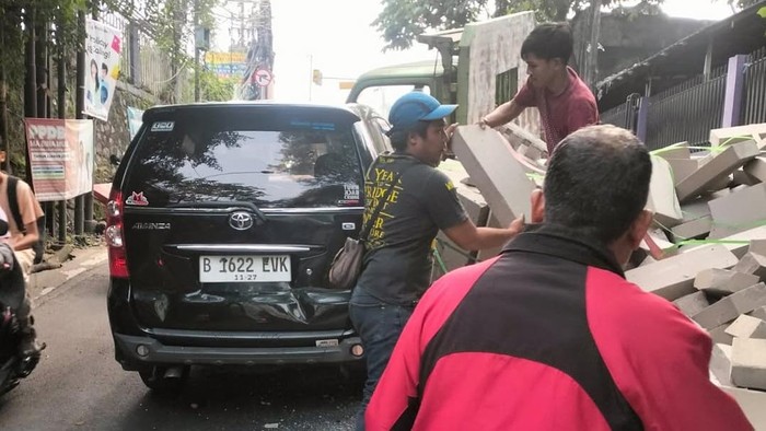 Truk muatan hebel terguling dan menimpa mobil di tanjakan Sawangan, Depok, Rabu (16/7/2025).