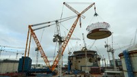 Derek darat Big Carl mengangkat atap kubah seberat 245 ton ke gedung reaktor kedua di pembangkit listrik tenaga nuklir Hinkley Point C dekat Bridgwater, Inggris, Kamis (17/7/2025). Foto: REUTERS/Isabel Infantes