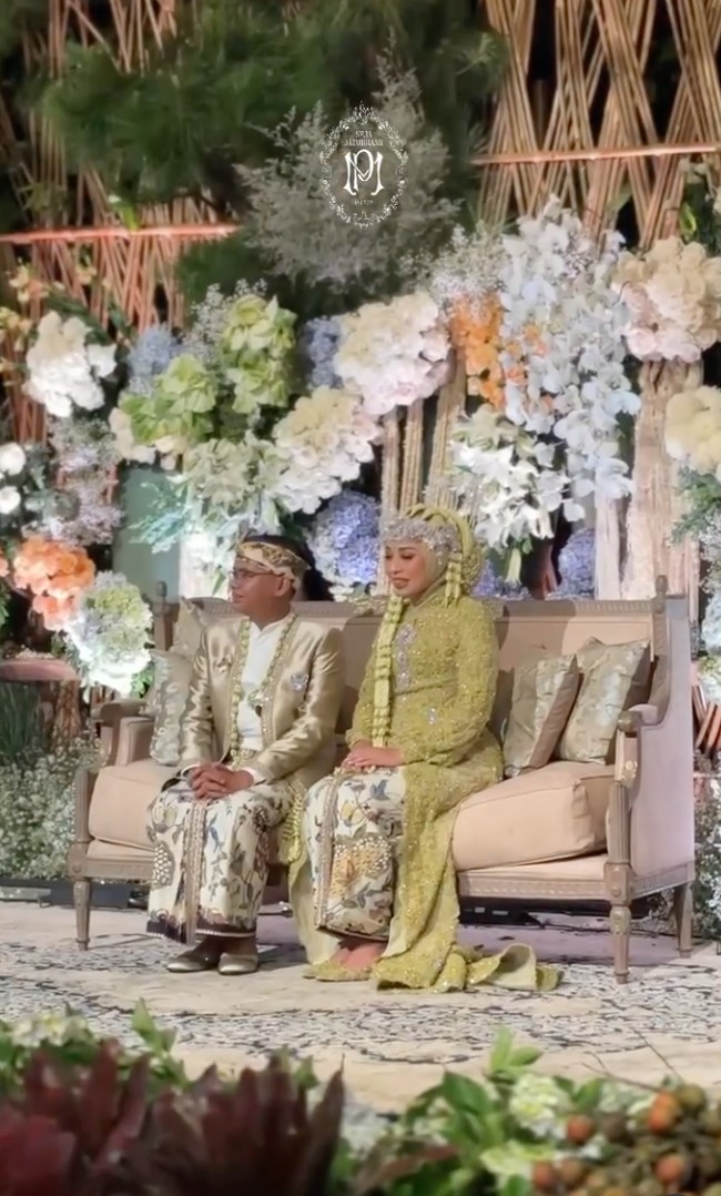 Senada dengan busana kedua pengantin, dekorasi acara juga didominasi oleh warna hijau. Dipadukan dengan bunga berwarna biru, putih, dan oranye, membuat  dekorasi jadi terlihat lebih hidup dan berwarna. Foto: Instagram/@putri.karlina14
