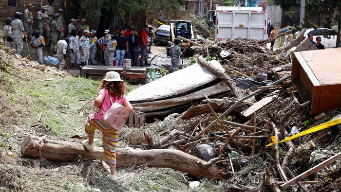 Penampakan Sisa-sisa Banjir Hebat yang Terjang Zapopan Meksiko A woman works to remove debris caused by flooding in the aftermath of heavy rains, in Zapopan, Mexico, July 16, 2025. REUTERS/Michelle Freyria