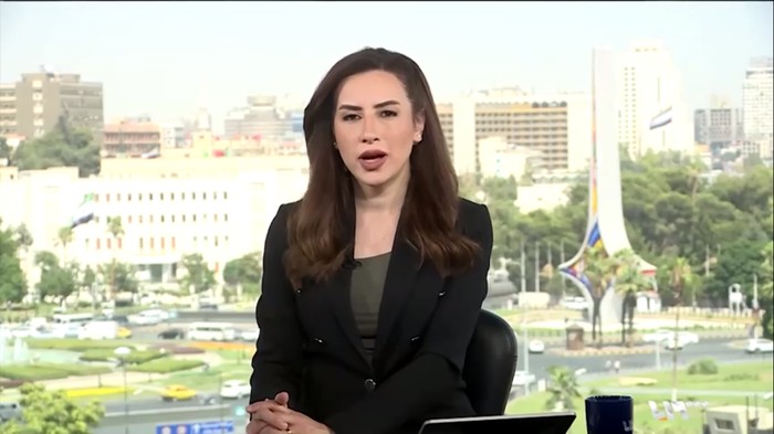 Pembawa berita Syria TV melakukan siaran di Damaskus, Suriah, Rabu (16/7/2025). Di tengah siaran terjadi serangan udara Israel menghantam Kementerian Pertahanan dan kantor TV negara di Damaskus pada Rabu (16/7/2025), membuat pembawa berita Syria TV langsung panik dan lari saat siaran langsung terhenti. (REUTERS/Syria TV)