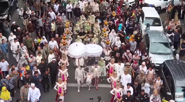 Maula Akbar yang mengenakan baju adat Sunda memberikan 90 gram logam mulia, sembilan ekor sapi, sembilan ekor ayam pelung Cianjur, sembilan tambun bibit ikan gurame,sembilan jenis padi, dan 99 jenis bibir kayu sebagai persembahan kepada istri dan keluarga. Foto: YouTube Kang Dedi Mulyadi