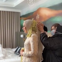 Di acara akad nikah Putri memilih tampil anggun dalam balutan kebaya tradisional bernuansa krem dan emas muda yang kaya dengan bordiran motif floral dan payet. Kebaya tersebut dipadukan dengan kain batik berwarna coklat. Foto: Instagram/@putri.karlina14