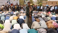 Dalam pelaksanaan salat ini, tampak bodyguard berjaga di sekitar lokasi. Penjagaan ketat dilakukan karena situasi keamanan di Yaman masih rawan konflik, sehingga kerumunan mahasiswa dan dosen berisiko menjadi target serangan. (REUTERS/Khaled Abdullah)  