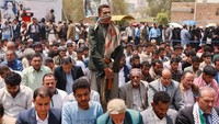 Seorang pengawal berjaga saat mahasiswa dan dosen Universitas Sanaa melaksanakan salat Istisqa di halaman kampus, Sanaa, Yaman, Rabu (16/7/2025). Doa khusus meminta turunnya hujan tersebut digelar sebagai respons atas krisis kekeringan yang semakin parah. (REUTERS/Khaled Abdullah)  