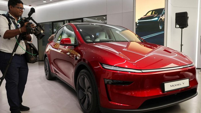 Tesla Buka Showroom Pertama di India, Luncurkan Model Y People are seen outside the Tesla showroom ahead of its opening in Mumbai, India, July 15, 2025. REUTERS/Francis Mascarenhas
