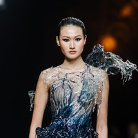 Sebagai penutup yang apik, hadir gaun dengan bodice berbentuk semburan air yang terbuat dari plastik. Ini adalah gaun para Aquarian. Saya memanfaatkan plastik yang biasa digunakan untuk menutup meja warteg, ungkap Seba yang telah mempersiapkan koleksi ini sejak setahun lalu. Melalui “The Sign”, Sebastian Gunawan tidak hanya menawarkan busana, tetapi juga narasi personal tentang keunikan dan identitas yang patut dirayakan dalam balutan mode. (Foto: Dok. Sebastian Gunawan Signature)