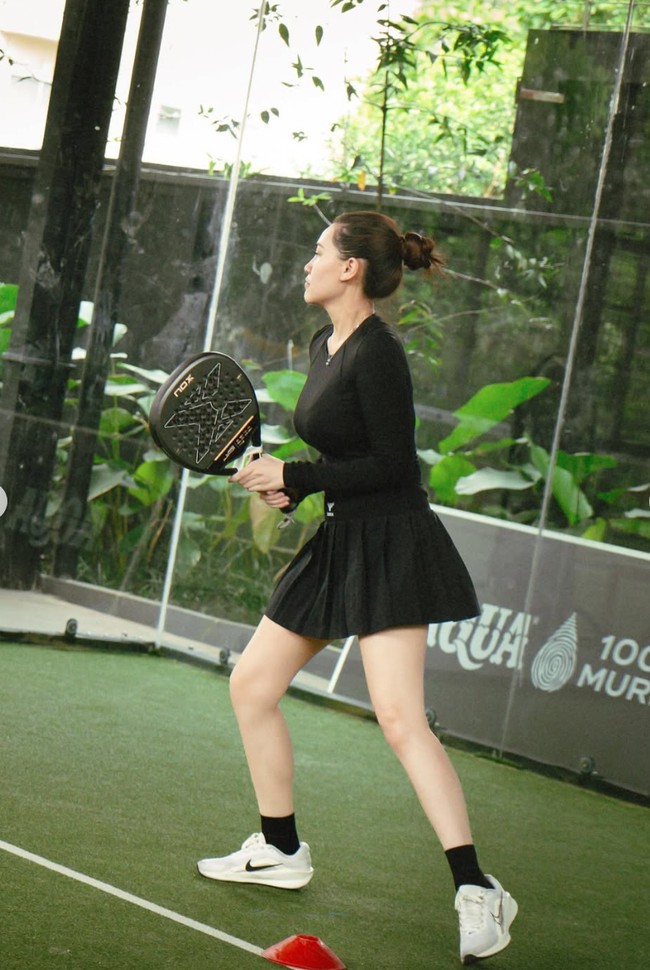 Ia memadukan atasannya dengan rok mini model lipit yang memberi kesan sporty sekaligus feminin. Untuk alas kaki, Aaliyah mengenakan sneakers putih yang mencolok dan memberi kontras sempurna dengan outfit hitamnya. Foto: Instagram/@aaliyah.massaid