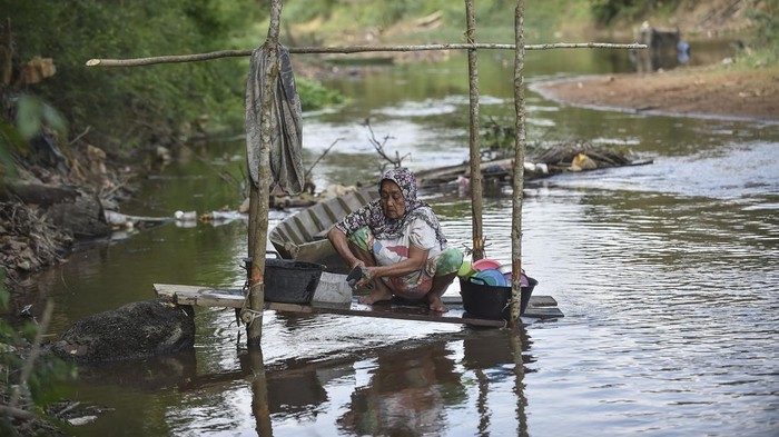 Kemarau Keringkan Sumur, Warga Muaro Jambi Andalkan Sungai untuk MCK Warga mencuci peralatan dapur di Sungai Kumpeh yang surut di Desa Sumber Jaya, Muaro Jambi, Jambi, Jumat (18/7/2025). Beberapa warga di daerah itu terpaksa menggunakan air sungai untuk mandi, cuci, dan kakus (MCK) karena sumur yang biasa digunakan sehari-hari mengalami kekeringan akibat kemarau sejak dua bulan terakhir. ANTARA FOTO/Wahdi Septiawan/bar