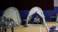 Warga duduk di tenda evakuasi darurat setelah wilayahnya terdampak hujan deras dan banjir. REUTERS/Kim Hong-Ji